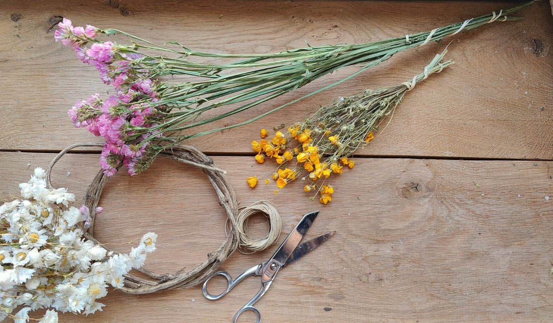bottes de fleurs séchées sur une table d'atelier