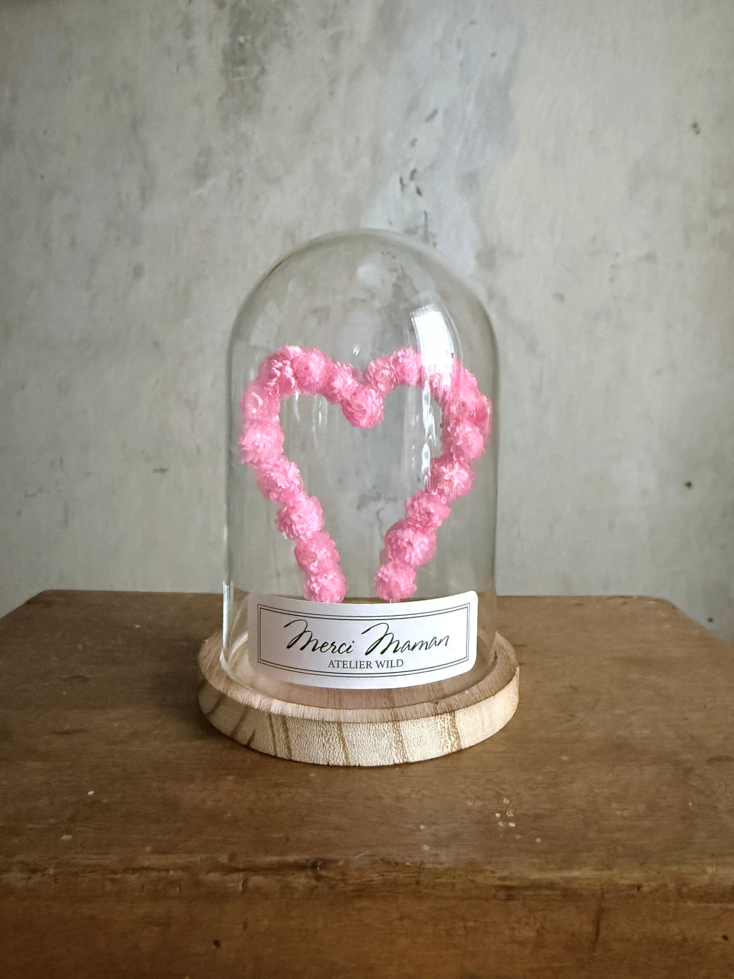 Création florale artisanale en immortelles roses sous verre
