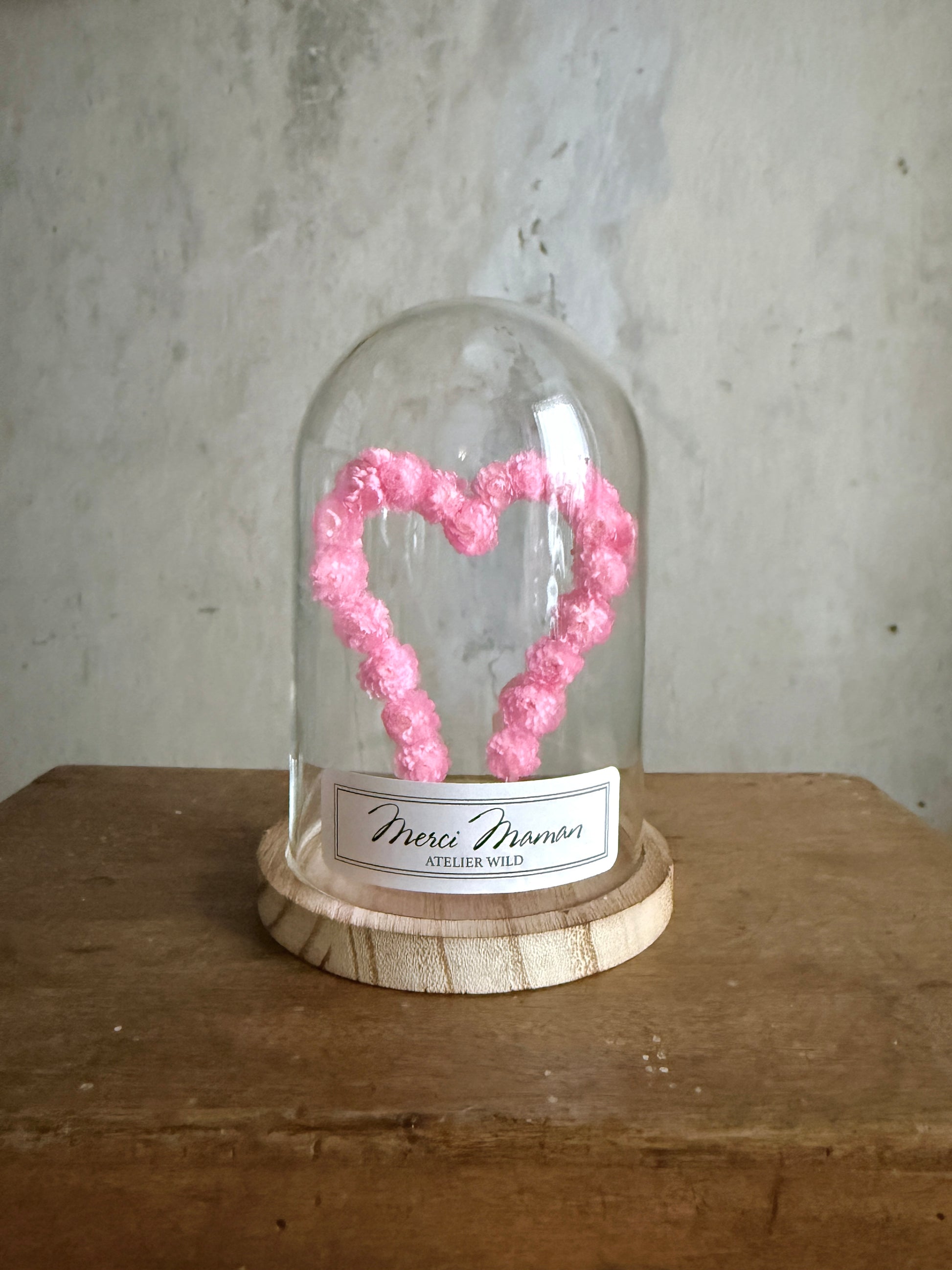 Création florale artisanale en immortelles roses sous verre
