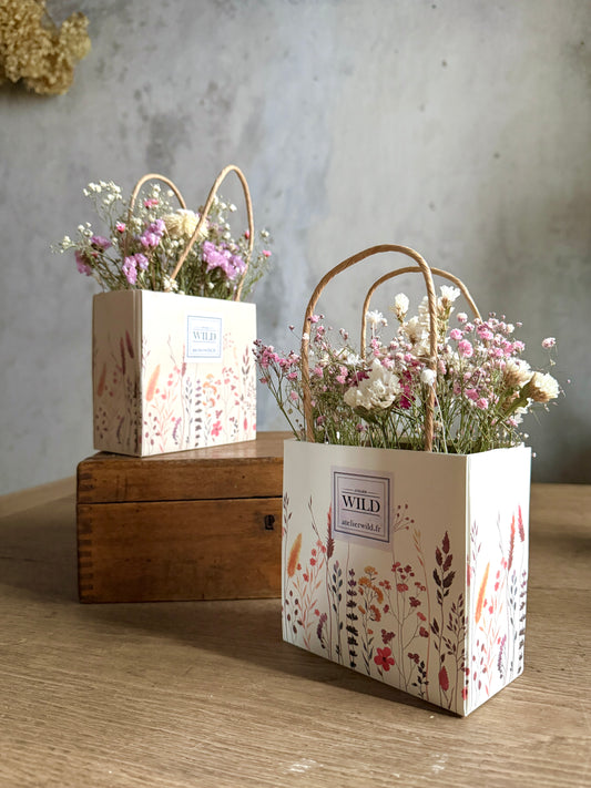 Création florale durable en fleurs séchées dans un sac cadeau
