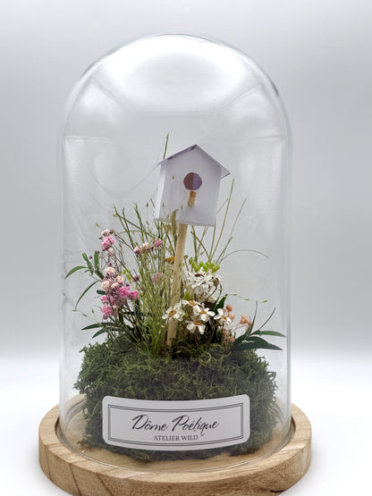 Petit paysage fleuri sous cloche avec nichoir décoratif

