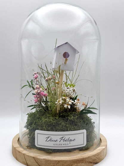 Petit paysage fleuri sous cloche avec nichoir décoratif fond blanc

